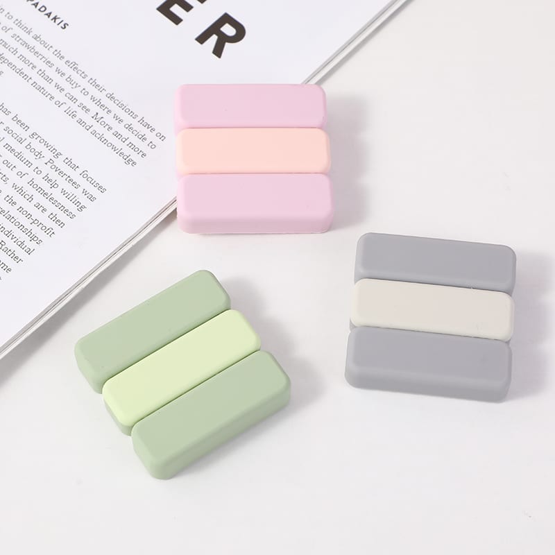 Tres protectores antigolpes cuadrados con diseño de tres franjas en tonos rosa, verde y gris