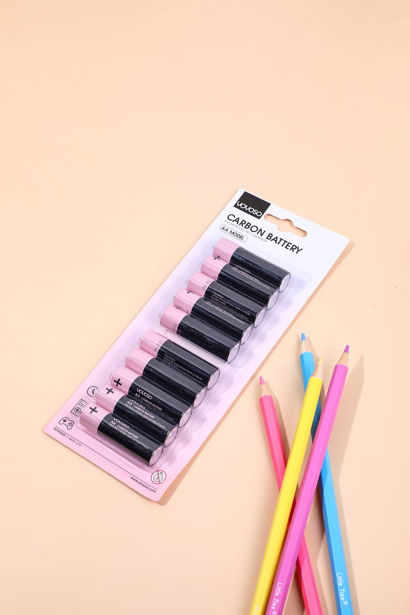 Paquete de diez pilas AA en blister con lápices de colores en superficie beige