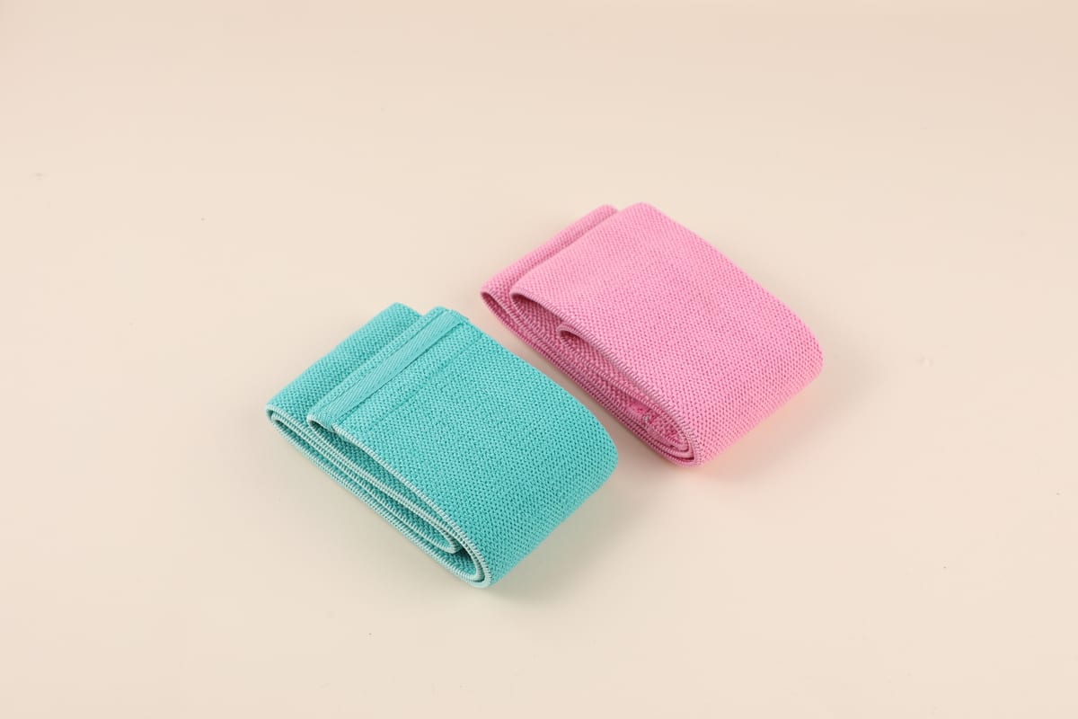 Bandas elásticas de tela dobladas en tonos verde agua y rosado