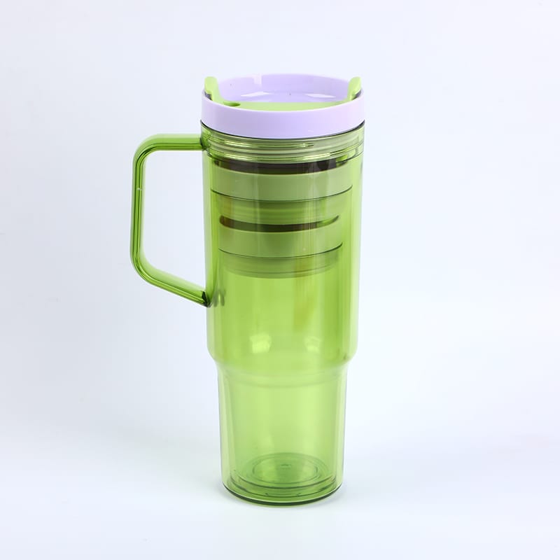 Vaso verde translúcido con asa lateral y vasos pequeños anidados en su interior