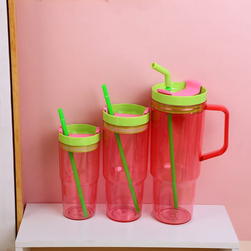 Trío de vasos rojos en tres tamaños con tapas verdes y sorbetes