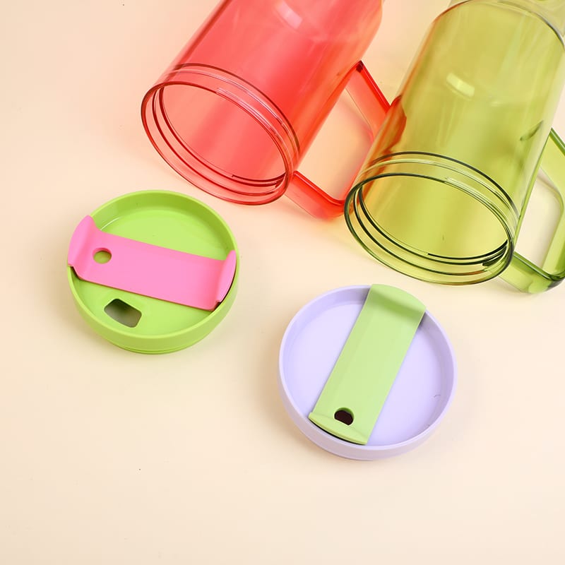 Vasos translúcidos rojo y verde destapados con sus tapas bicolor sobre la mesa