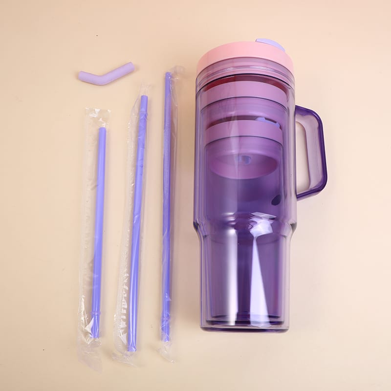 Vaso morado grande con dos vasos anidados adentro y tres sorbetes celestes al lado