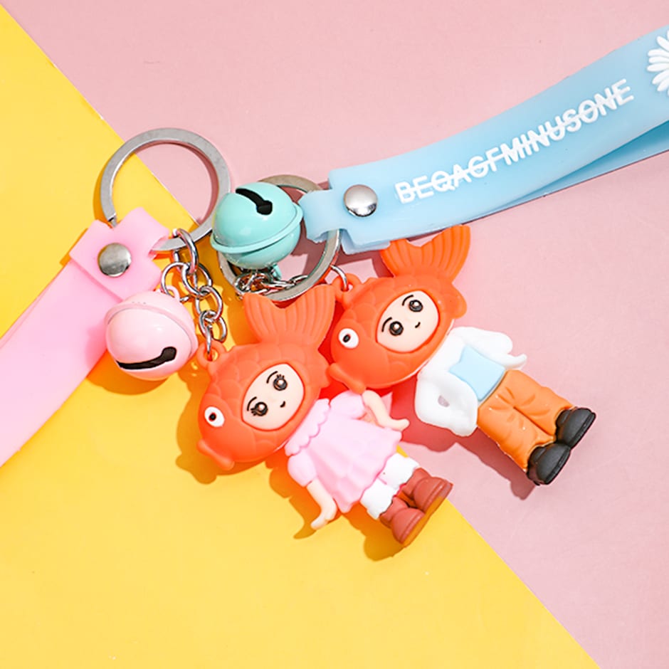 Detalle de los llaveros con muñeco de gorro en forma de pez naranja y cascabeles de colores