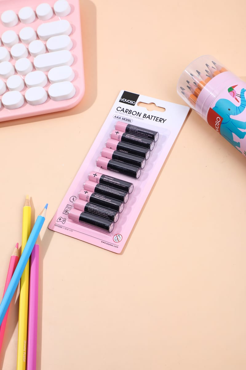 Paquete de diez pilas AAA sobre la mesa junto a lápices de colores.