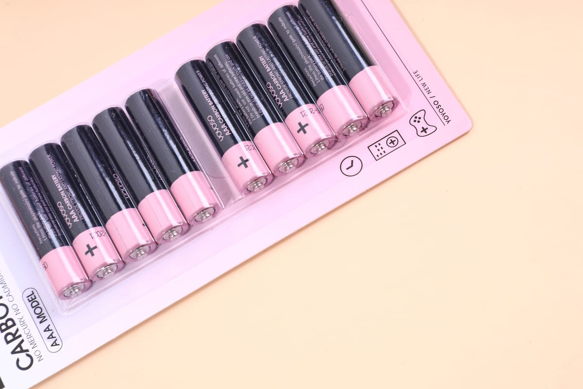 Acercamiento al paquete de 10 pilas AAA con cuerpo negro y extremos en rosa pastel.