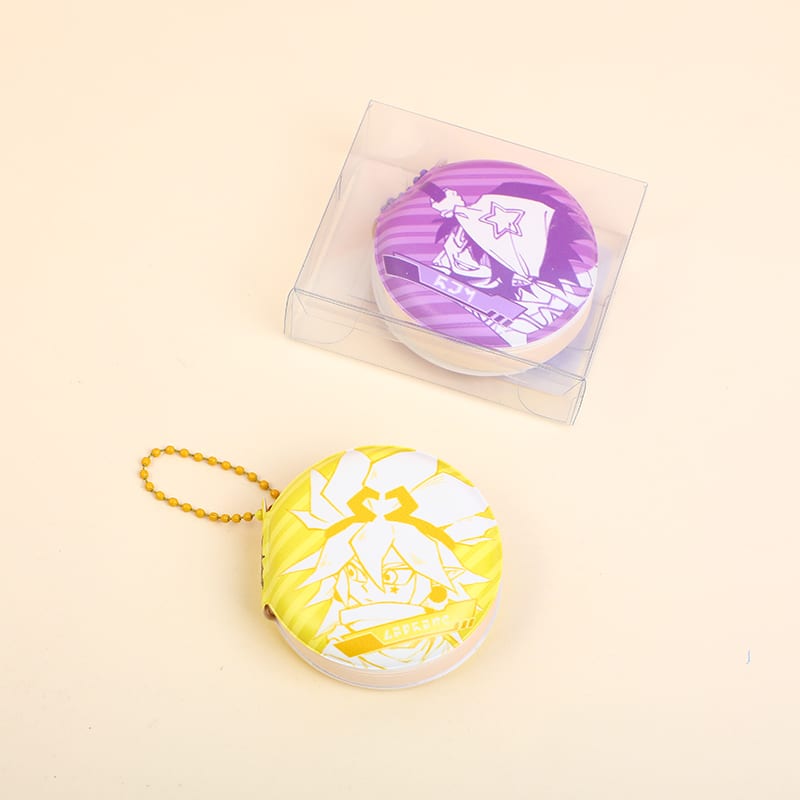 Mini libreta circular amarilla con cadena junto a otra libreta en caja transparente