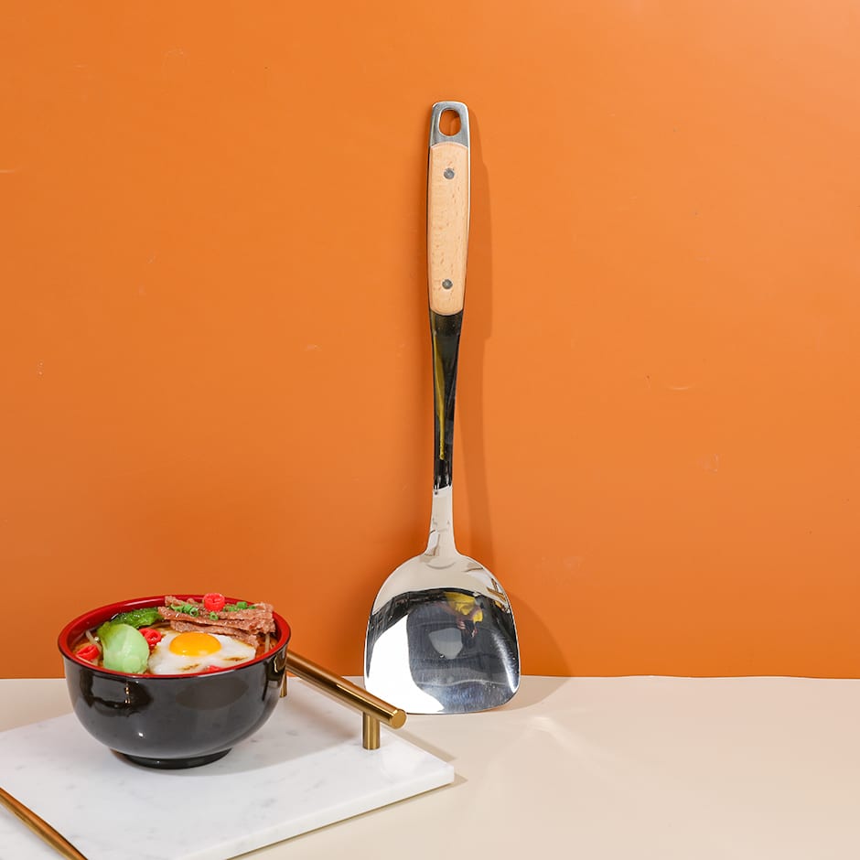 Espátula de cocina en posición vertical frente a fondo cálido