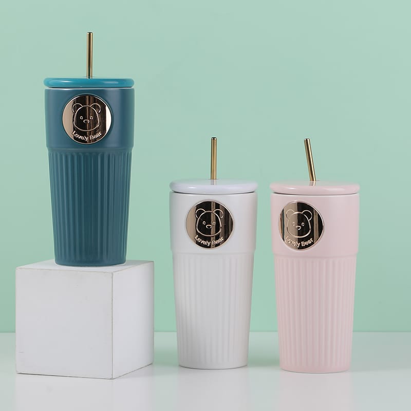 Tres vasos de cerámica acanalados en azul, blanco y rosa con sorbete metálico