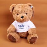 Muñeco de Peluche Oso Sentado con Camiseta Azul TEDDY ISLAND - 35 cm (Color Oscuro)